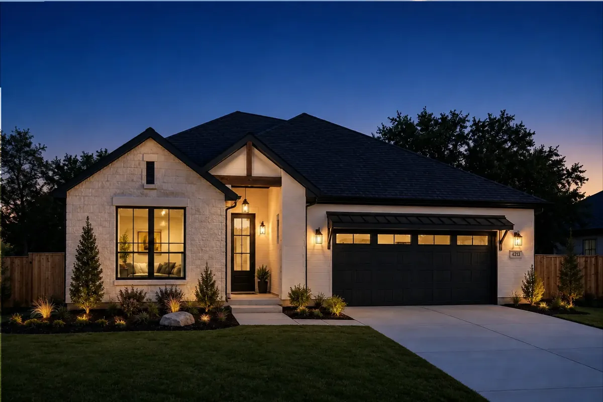 A house exterior at twilight with the windows lit